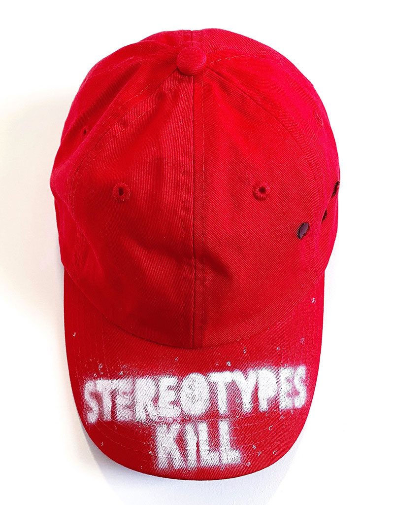 Mia B. Adams, STEREOTYPES KILL Project: Hat #10, 2018-present. Repurposed hats, spray paint. Courtesy of the artist.