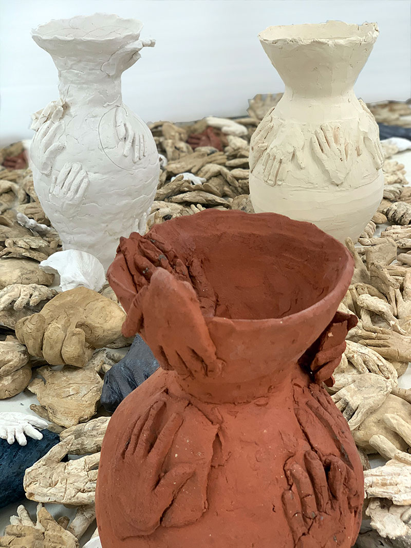 Patricia Sannit, Many Hands (hold me), 2021. Participatory project, volunteers made hundreds of clay hands while speaking about their experiences of isolation during the pandemic. Fired clay, wood, saw horse. Photo: Patricia Sannit.